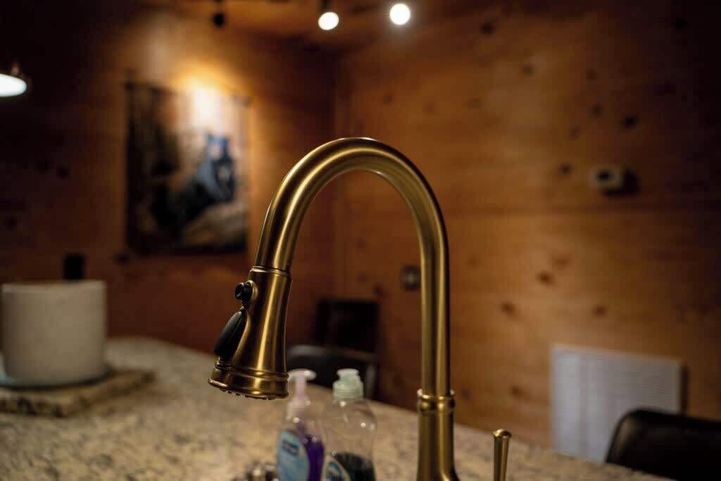 Ein Badezimmer mit einer Holzvertäfelung, einem Messingarmaturen und einer Ablage mit Pflegeprodukten.