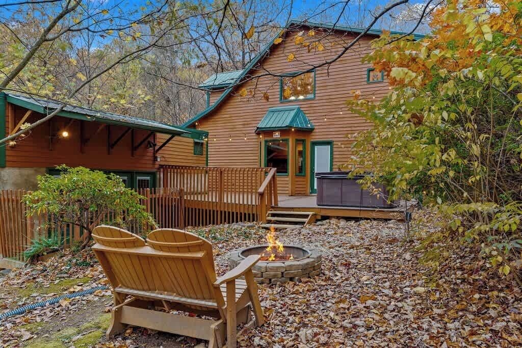 A wooden cabin with a fire pit, outdoor seating, and a covered porch.