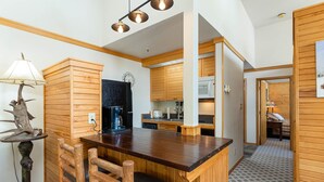 Una cocina moderna con armarios de madera, una isla central con asientos y un comedor.