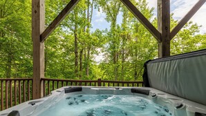 A hot tub with a wooden deck and a view of a forest. - Stags Leap in Yonahlossee  Pool Table, Indoor Pool, Tennis Courts (Boone)