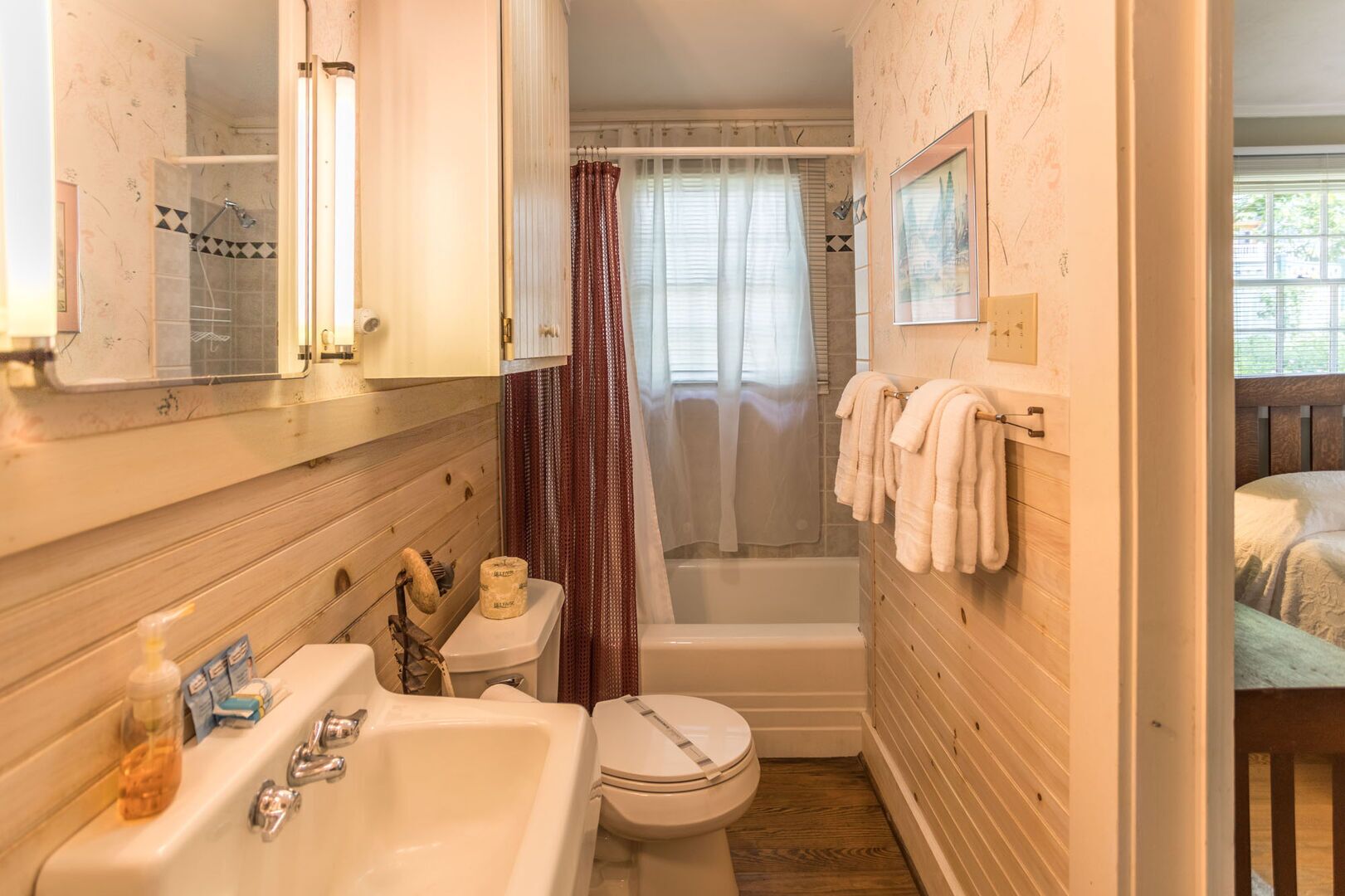 Een kleine badkamer met bad, toilet en douche.