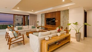 A modern living room with a sofa set, wooden coffee table, and a TV mounted on the wall.