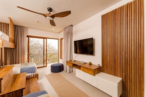 Ein modernes Schlafzimmer mit Bett, Schreibtisch aus Holz, Fernseher und großen Fenstern.