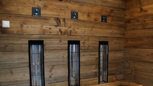 Un mur en bois avec trois barres métalliques verticales et un banc.