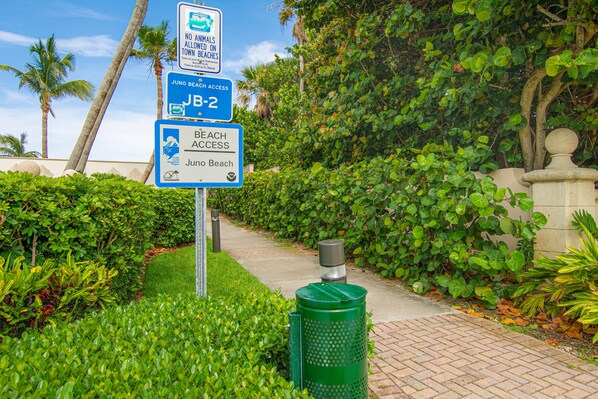 A pathway leading to a beach with signs indicating beach access and no animals allowed on town beaches. - Steps to Beach. Hidden Gem. Boutique Bungalow Chic. (Juno Beach)