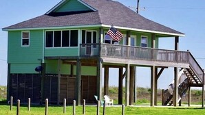 A two-story house with a balcony and a wooden deck. - MI CASA DEL MAR - So close to the beach, perfect house for 4! (Caplen)