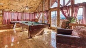 A wooden interior with a pool table, a ceiling fan, and large windows with curtains. - Priceless View - AWESOME MOUNTAIN VIEWS, $560 FREE tickets each paid day! (Sevierville)