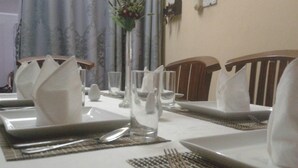 A dining table set with plates, cutlery, and napkins. - Onix Villa (Galle)