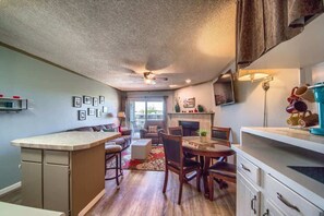 Una cocina compacta con comedor, ventilador de techo y chimenea.