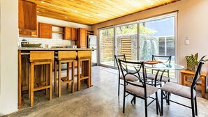Eine moderne Küche mit Holzschränken, einer Granit Arbeitsplatte und einer eingebauten Kochinsel mit Barhocker.