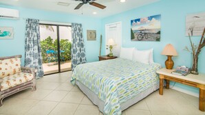 A bedroom with a bed, a nightstand, a lamp, a chair, and a ceiling fan. - Prime Location. Hidden Gem. Steps to Beach. Boutique Bungalow. Pet Friendly.  (Juno Beach)