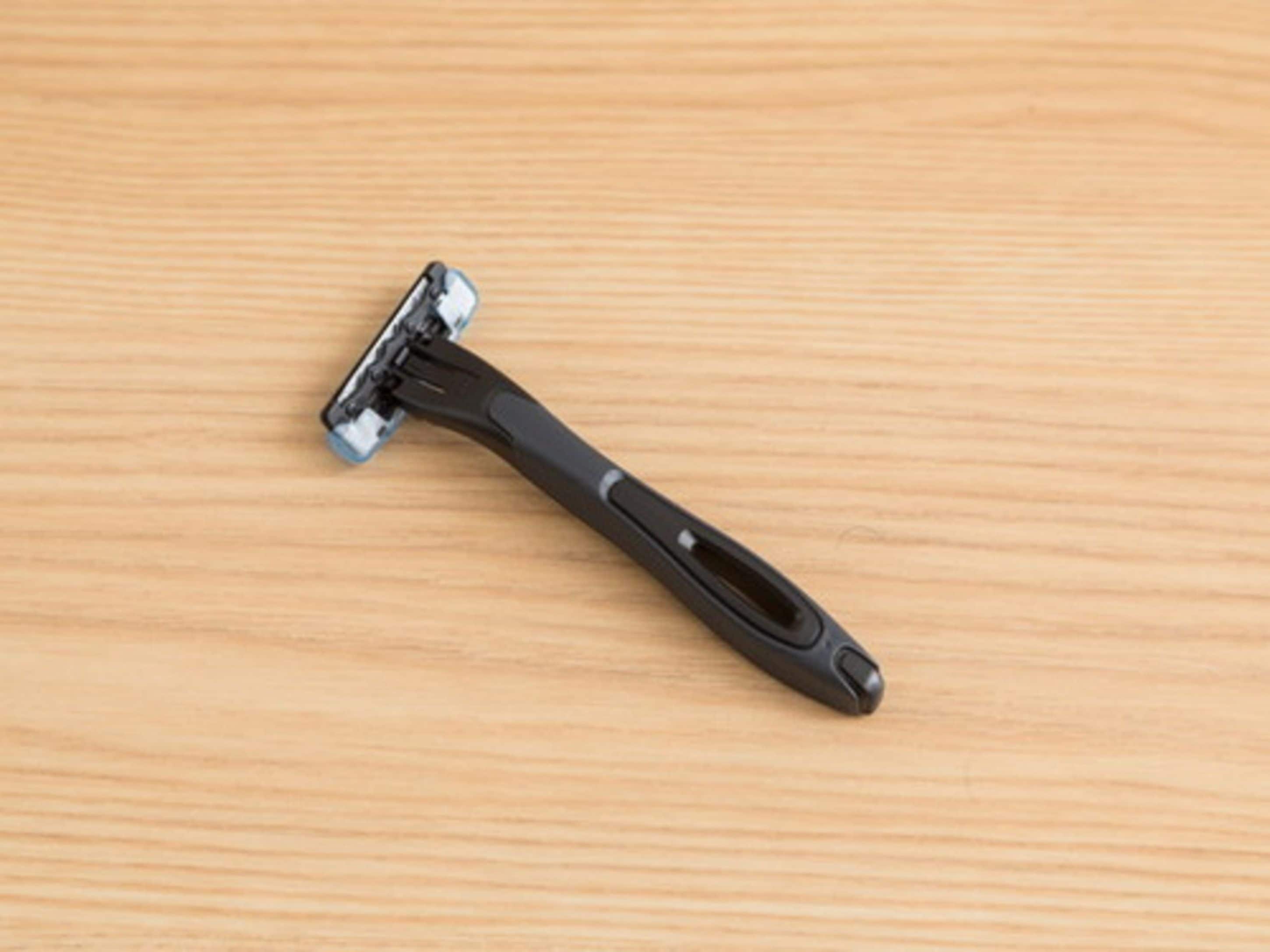 A straight razor on a wooden surface.