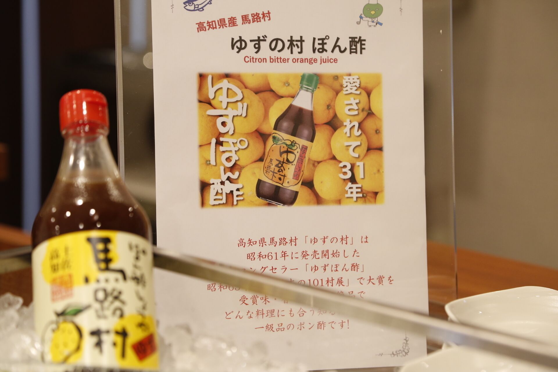 A bottle of citrus beverage with a label featuring Japanese text and an illustration of citrus fruits.