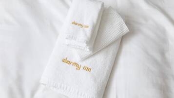 Une serviette blanche, soigneusement pliée, avec le nom « darmy inn » brodé en lettres dorées.