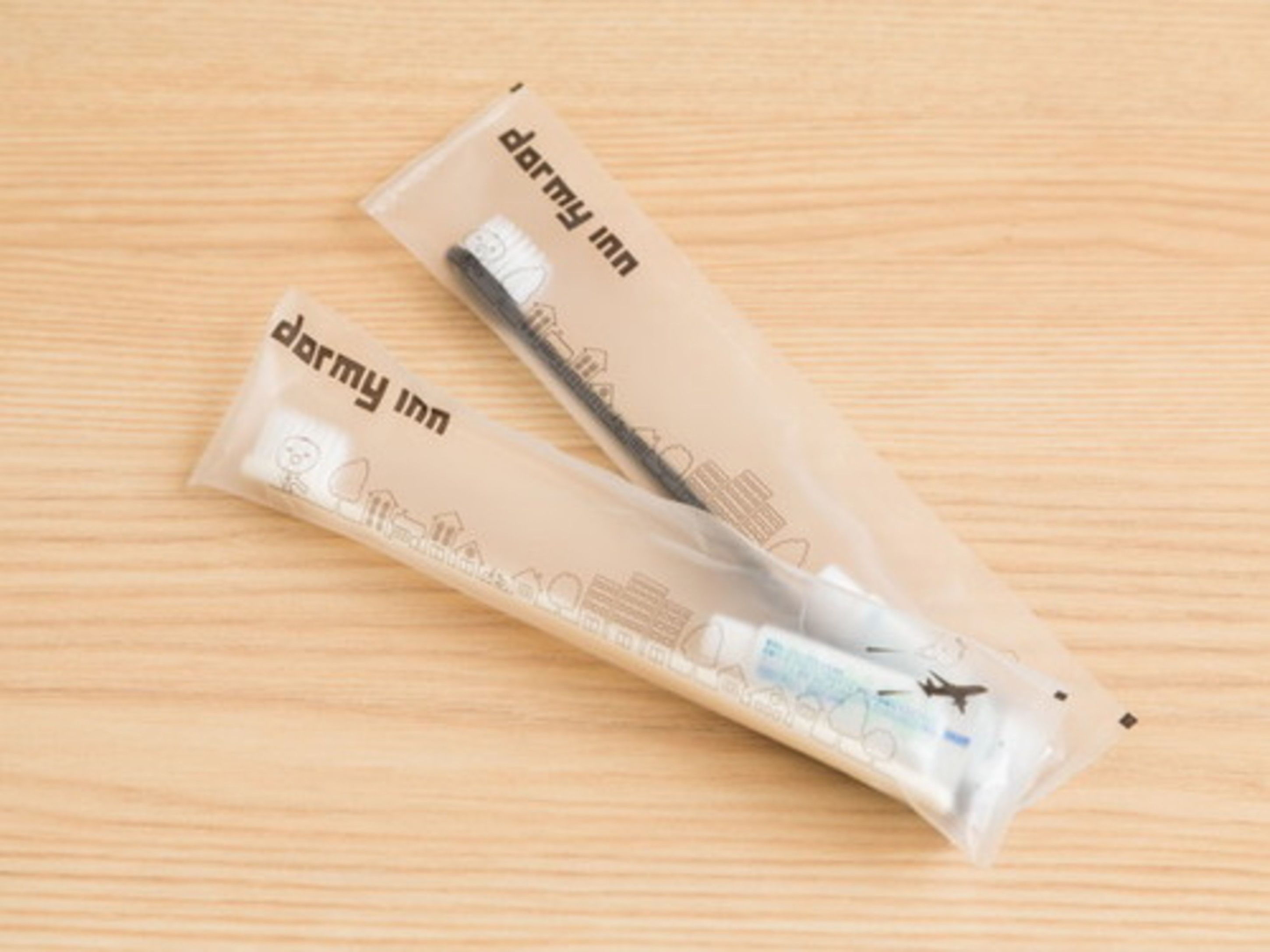 A package labeled 'darmy inn' with a pen and a small item inside, placed on a wooden surface.