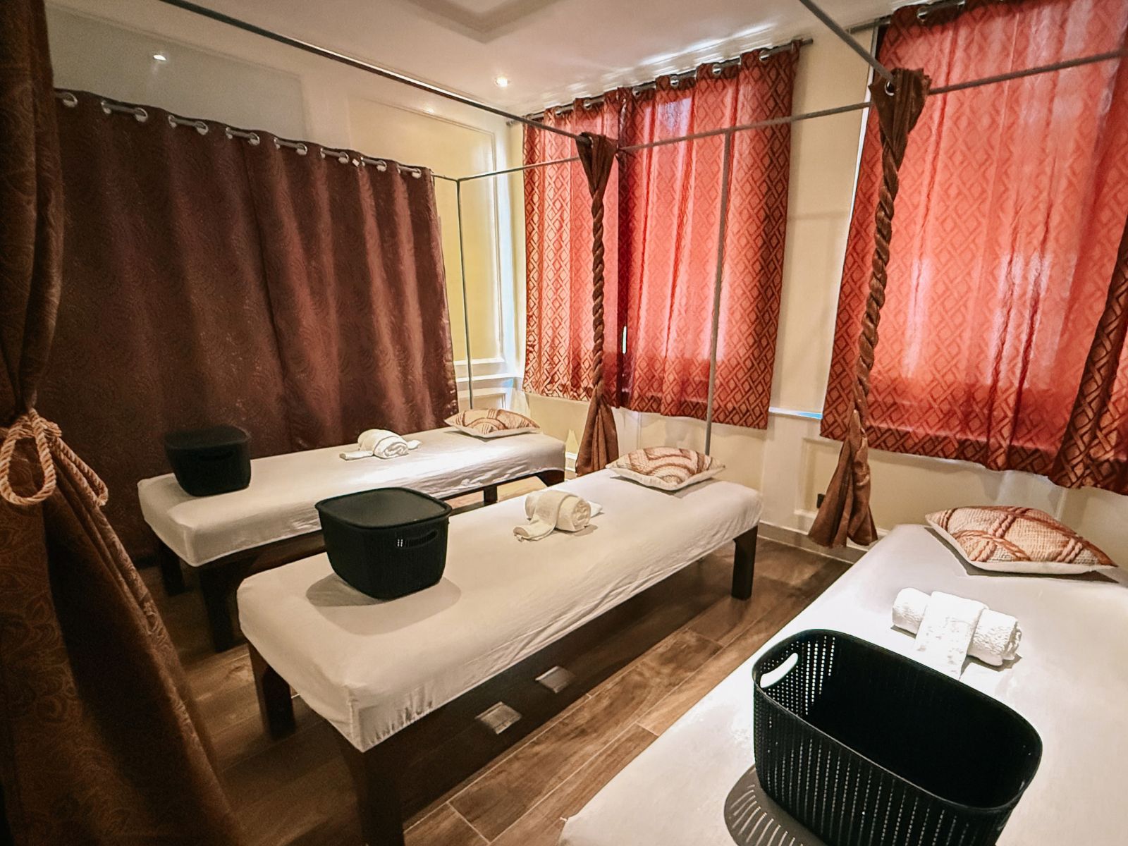 Habitación de hotel con dos camas, un cubo negro, una toalla blanca y una cesta negra.