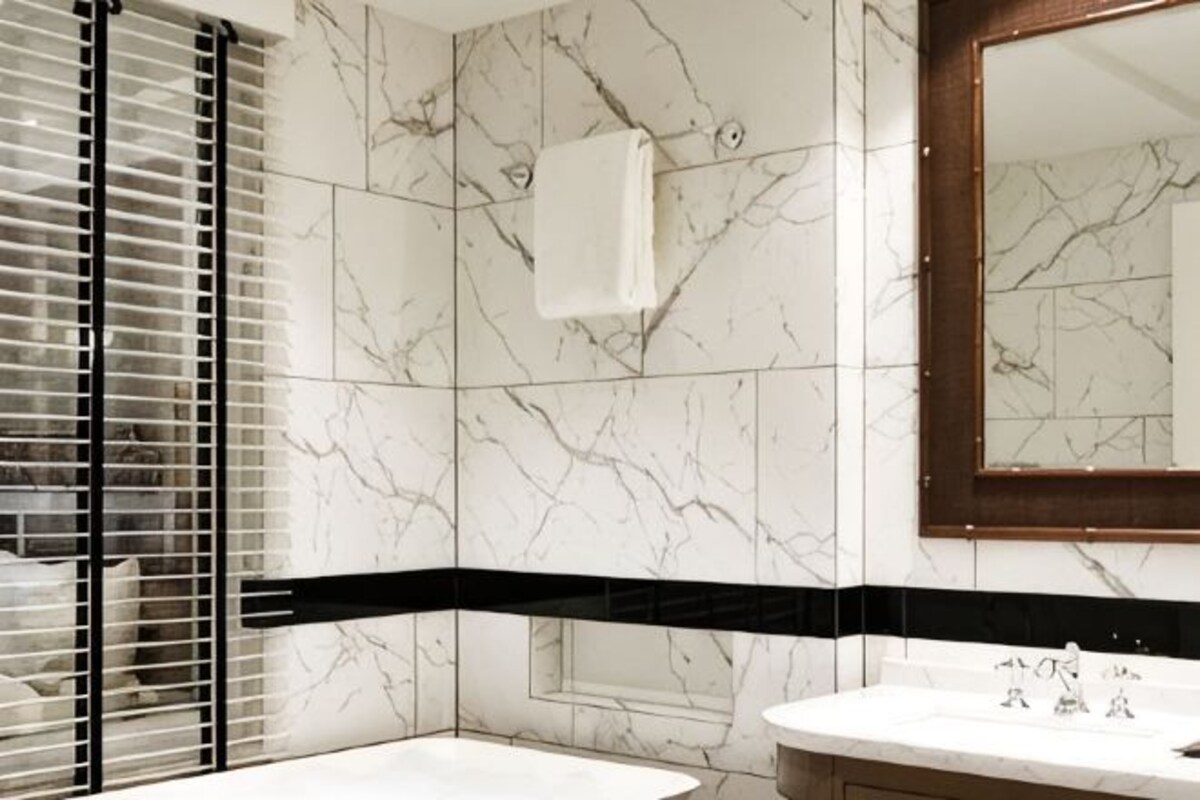 Une salle de bain avec une baignoire, un lavabo, un miroir et un porte-serviettes.