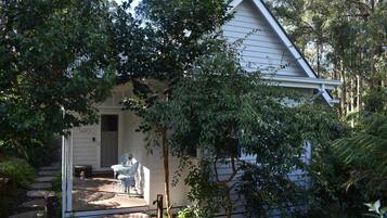 A house with a porch, a small table and chairs, and a door.