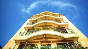Hotel com várias andares, varandas e céu azul límpido.