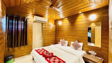 A wooden-paneled room with a bed, a nightstand, a mirror, and a ceiling fan.