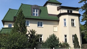 Un edificio a due piani con tetto verde e numerose finestre.