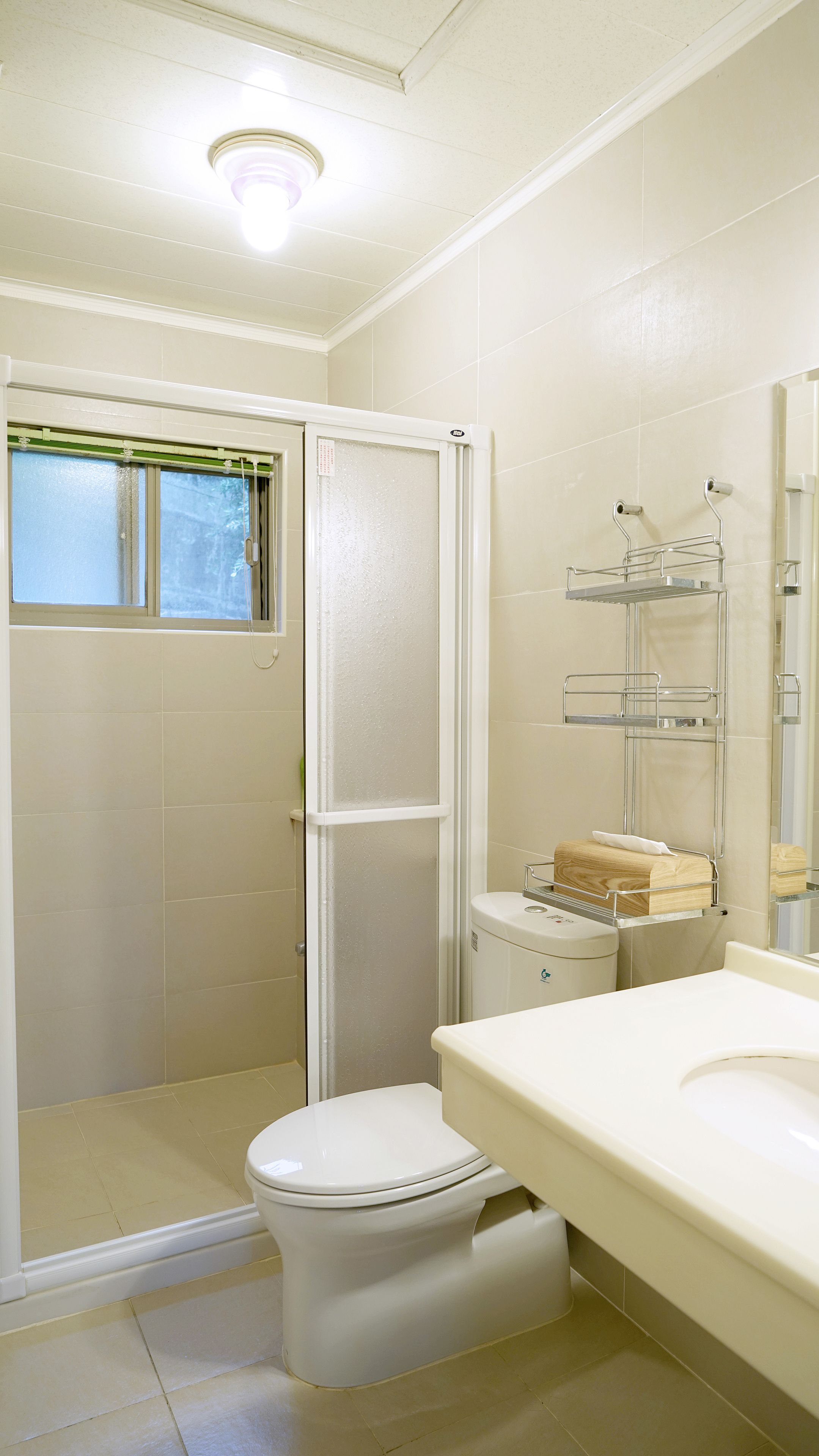A bathroom with a toilet, a shower, and a sink.