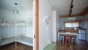 A room with bunk beds, a kitchenette, and a small dining area. - Lucidbonbon - Hostel (Seogwipo)