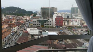A view from a window overlooking a cityscape with buildings, roads, and a hill in the distance. - The Octagon Ipoh (Ipoh)