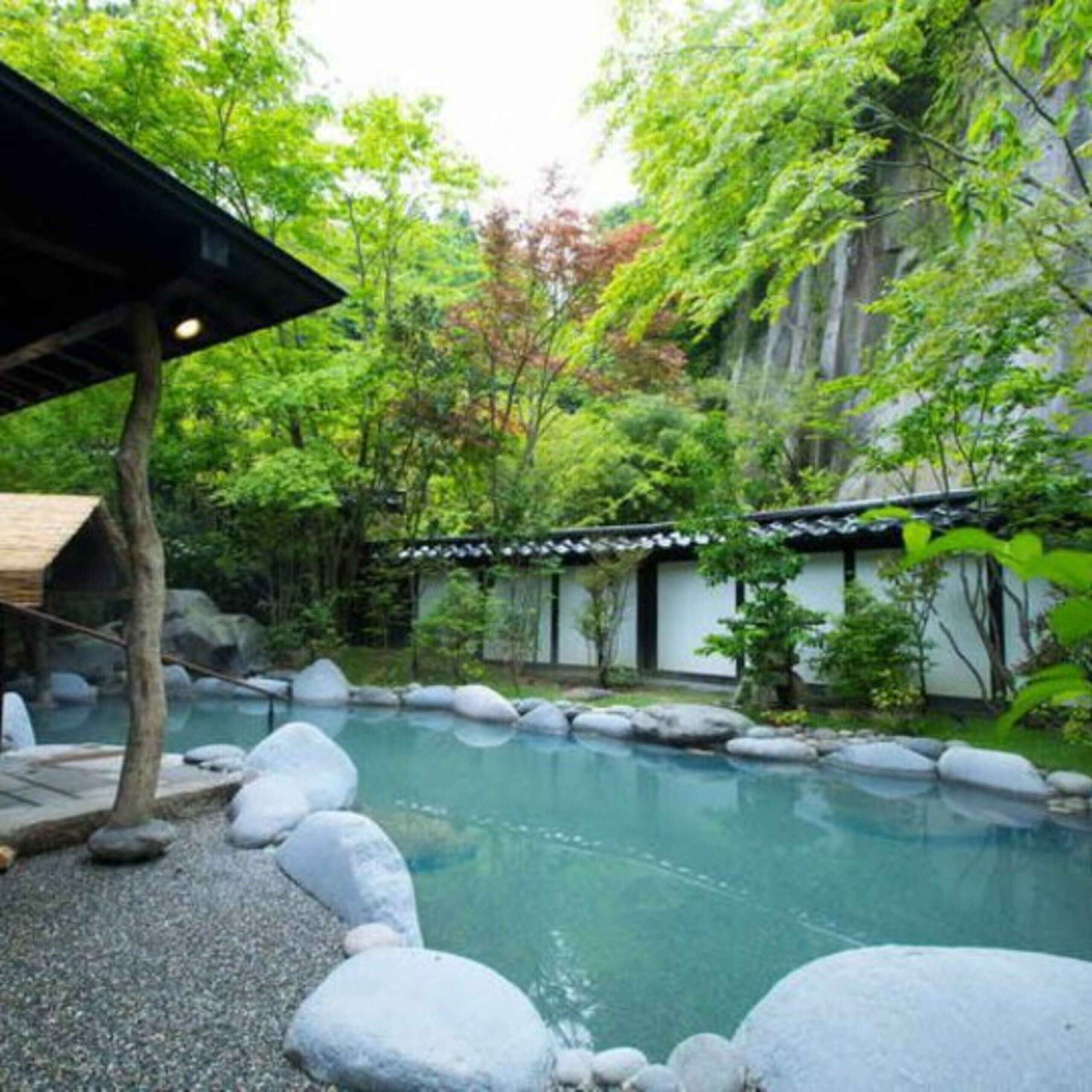 A traditional Japanese-style garden with a koi pond, surrounded by rocks and lush greenery.