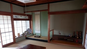 Una habitación japonesa tradicional con suelo de tatami, puertas correderas y una mesa de madera baja.