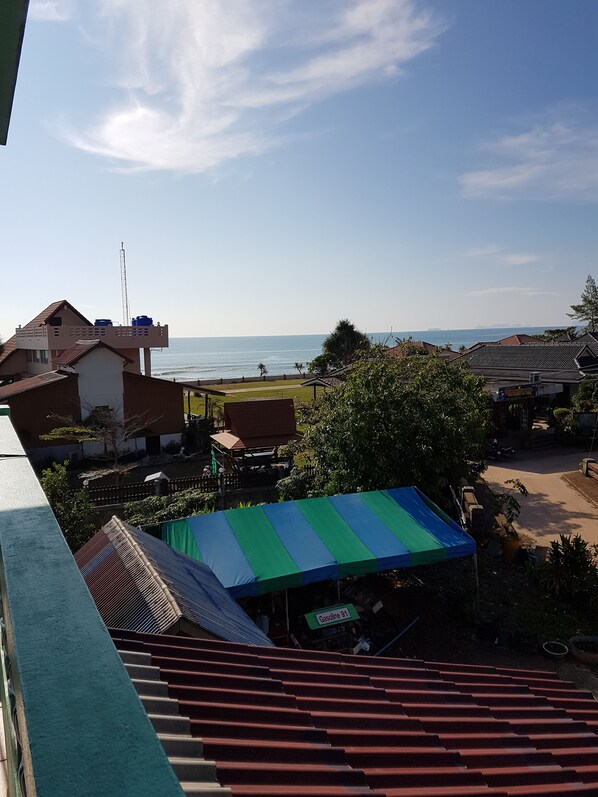 Vista costera con cielo despejado, una playa y edificios residenciales.