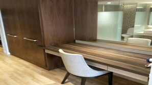 A modern bathroom with a wooden vanity, a mirror, and a toilet. - Greystone Haus at D' Majestic Place (Kuala Lumpur)