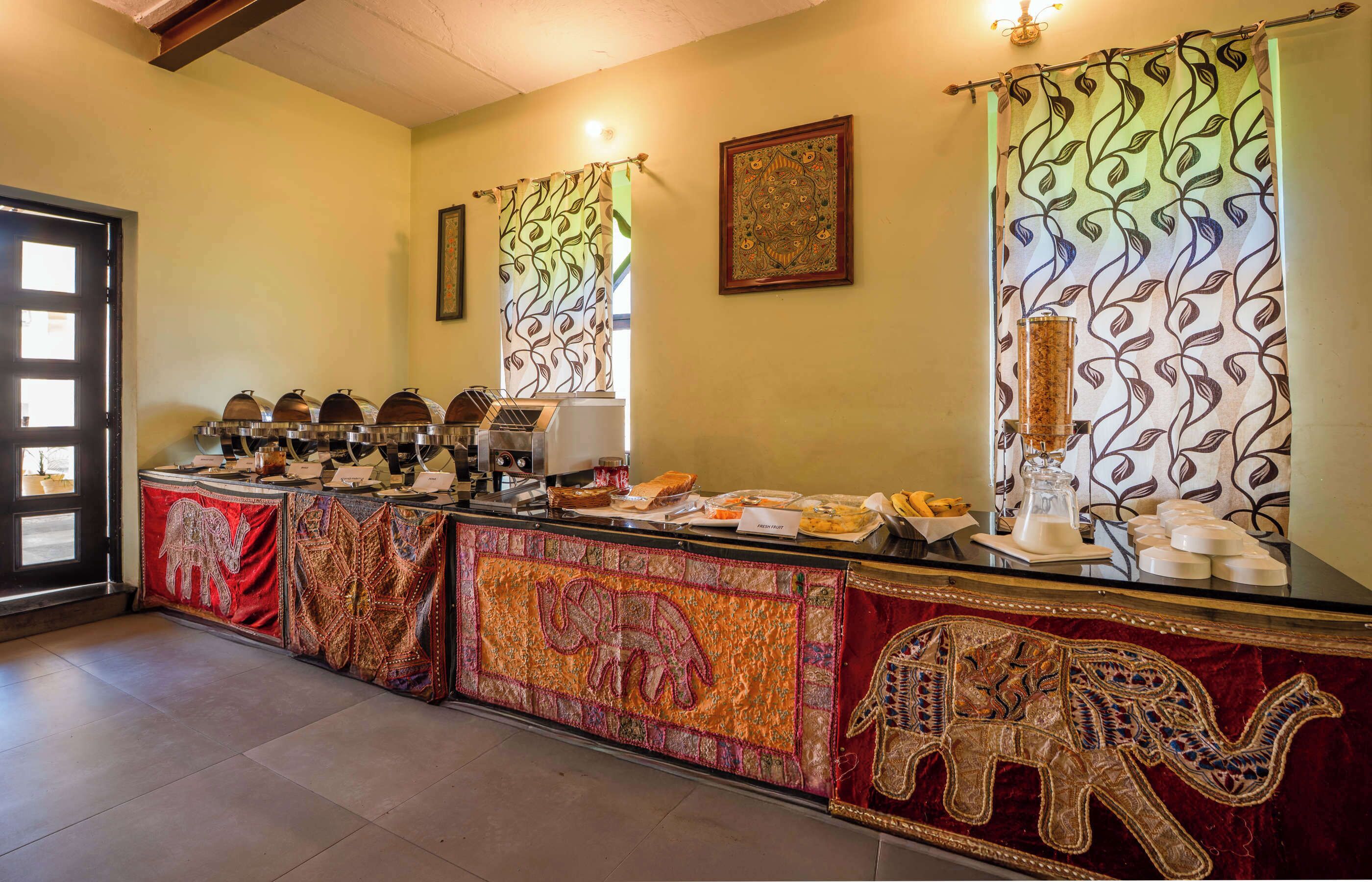 A reception desk with a patterned curtain, a framed artwork, and a glass container.