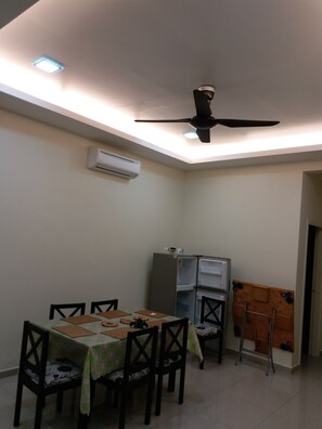 A dining area with a table set for four, a ceiling fan, and an air conditioning unit. - Homestay KS Botanic 21 (Kuala Selangor)