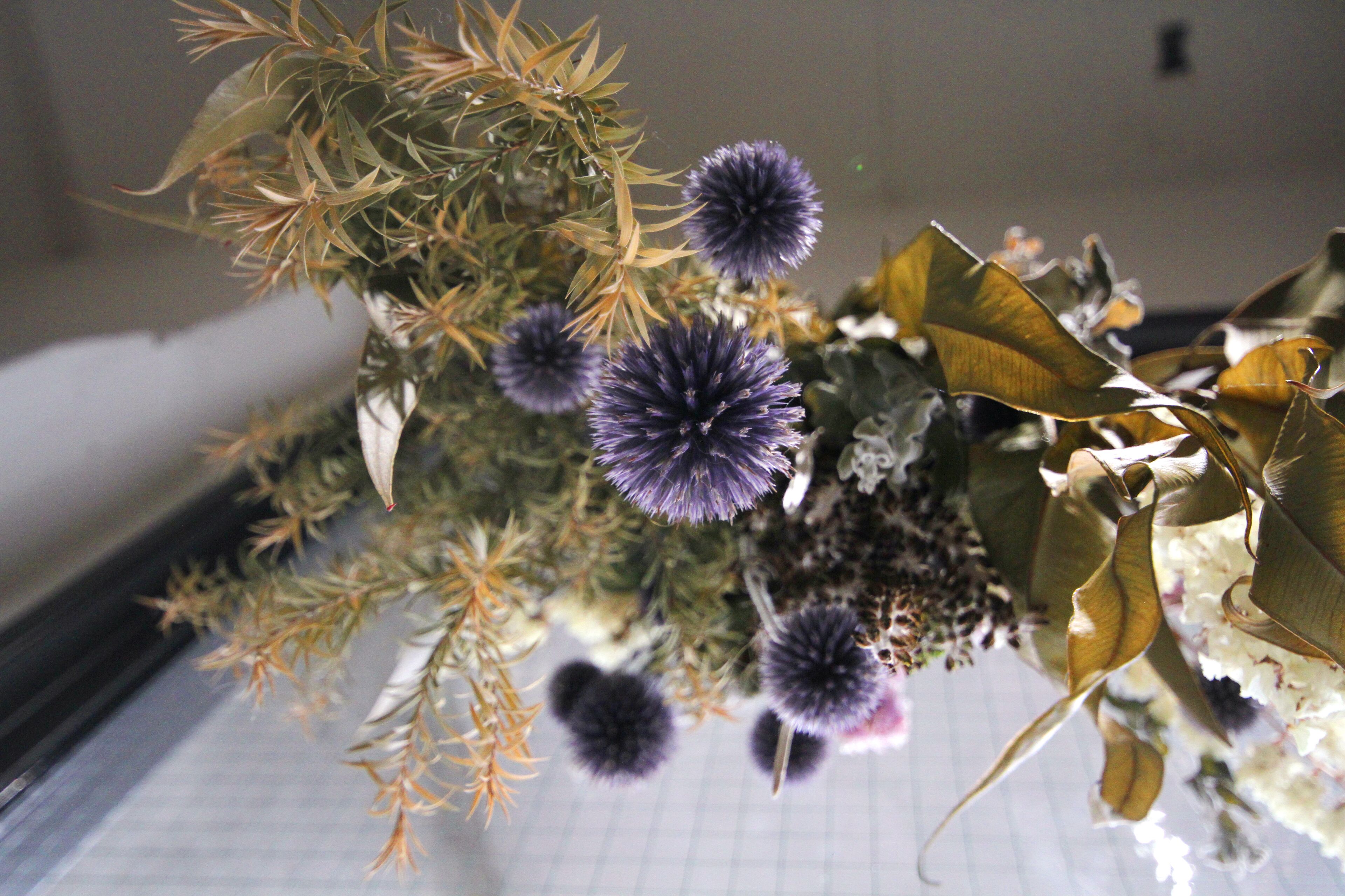 A close-up of a floral arrangement with purple flowers and green foliage.