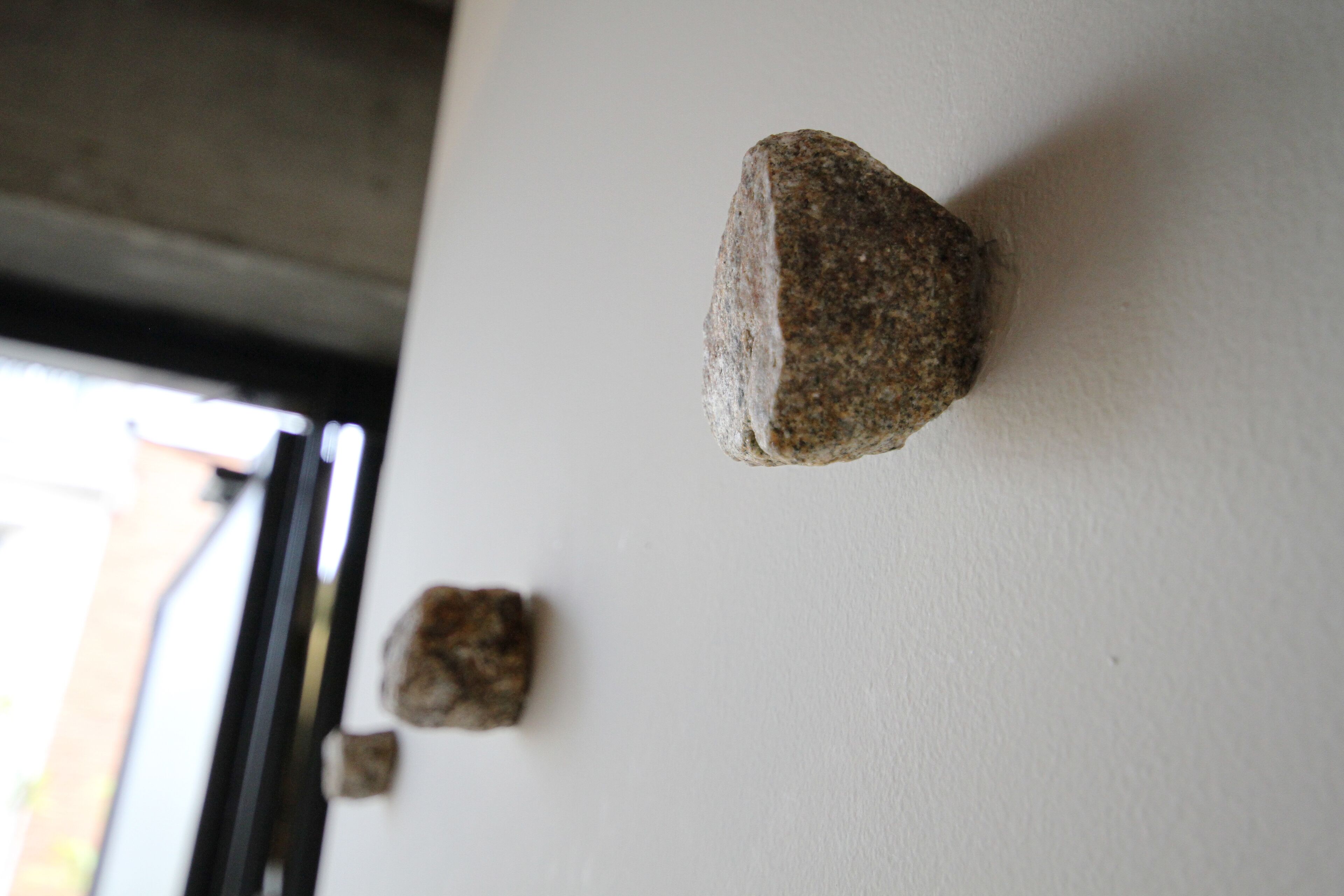 A stone wall with two stones mounted on it.