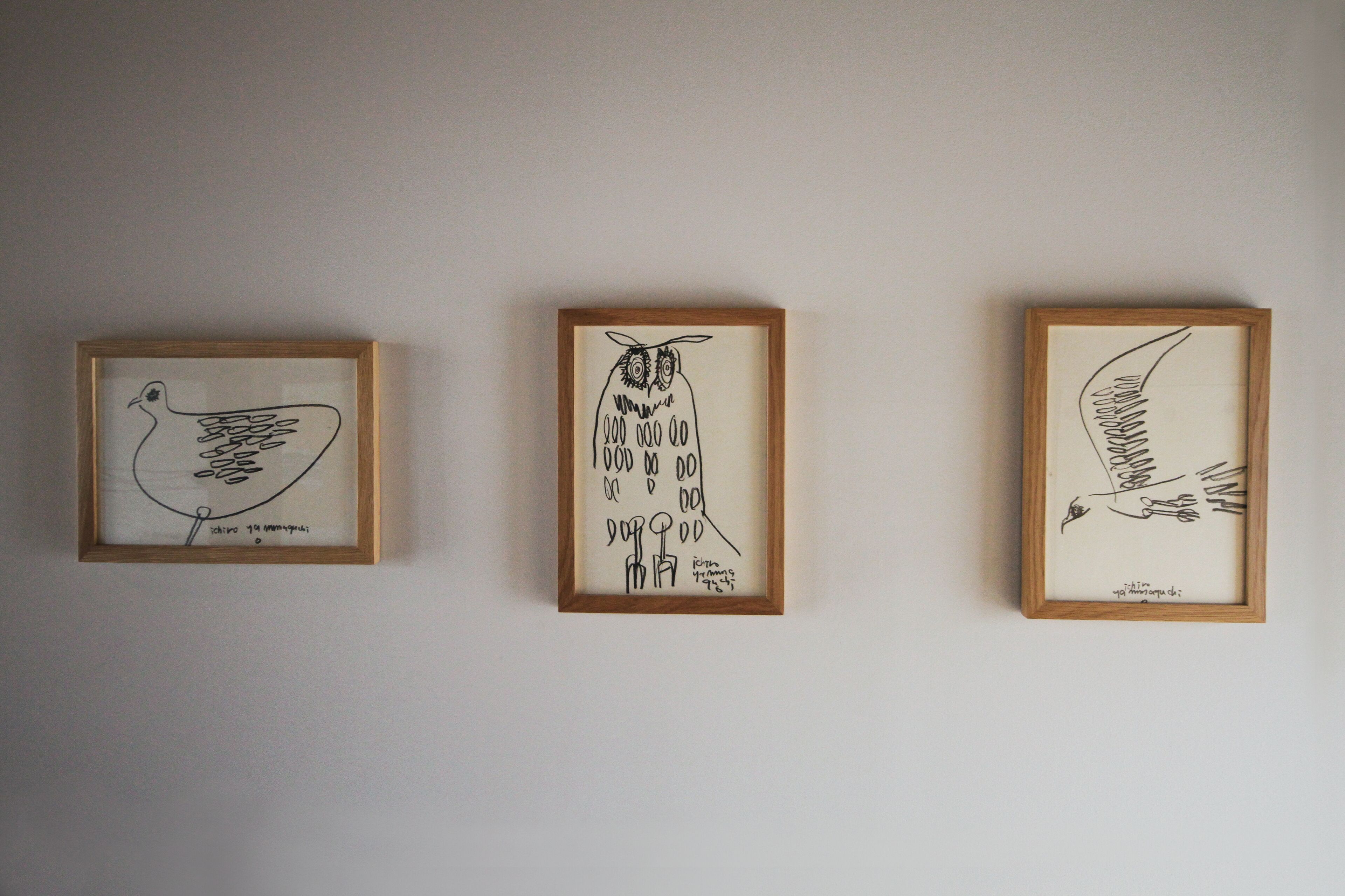 Three framed artworks on a wall.