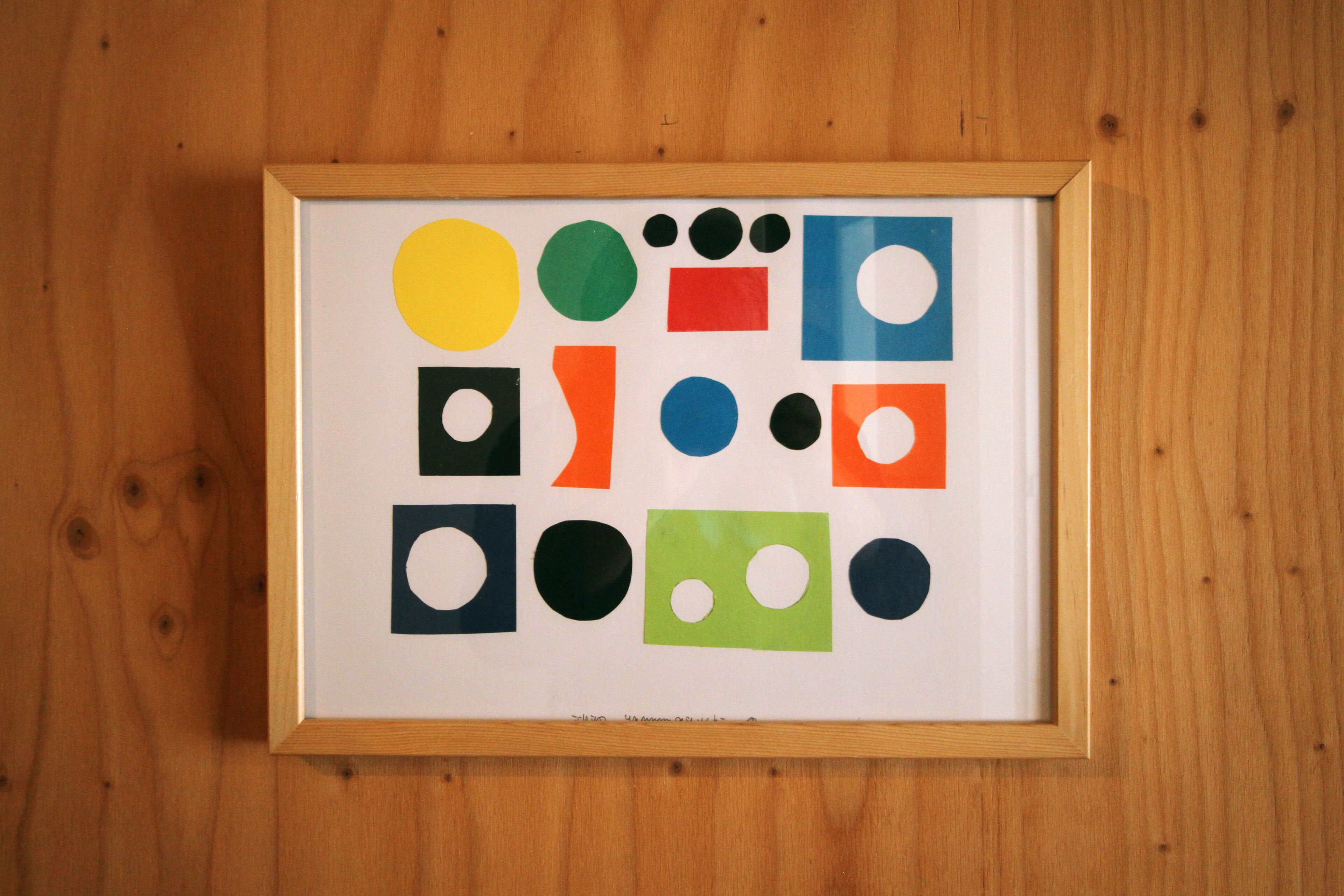 A framed artwork with various geometric shapes and colors.