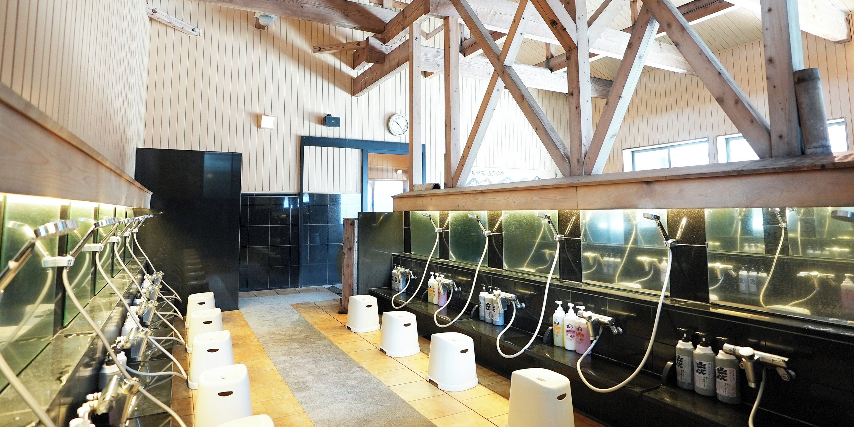 A public restroom with multiple sinks, hand dryers, and soap dispensers.