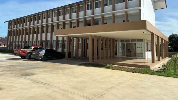 Un edificio moderno de varios pisos con techo plano y ventanas amplias.