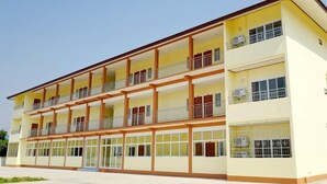 Un edificio de varios pisos con balcones, ventanas grandes y techo plano.