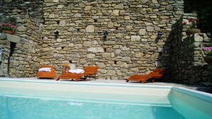 A stone wall with a pool and lounge chairs. - Ca'Luni (Casola in Lunigiana)