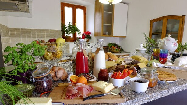 A kitchen counter with various food items and kitchenware. - Ca'Luni (Casola in Lunigiana)