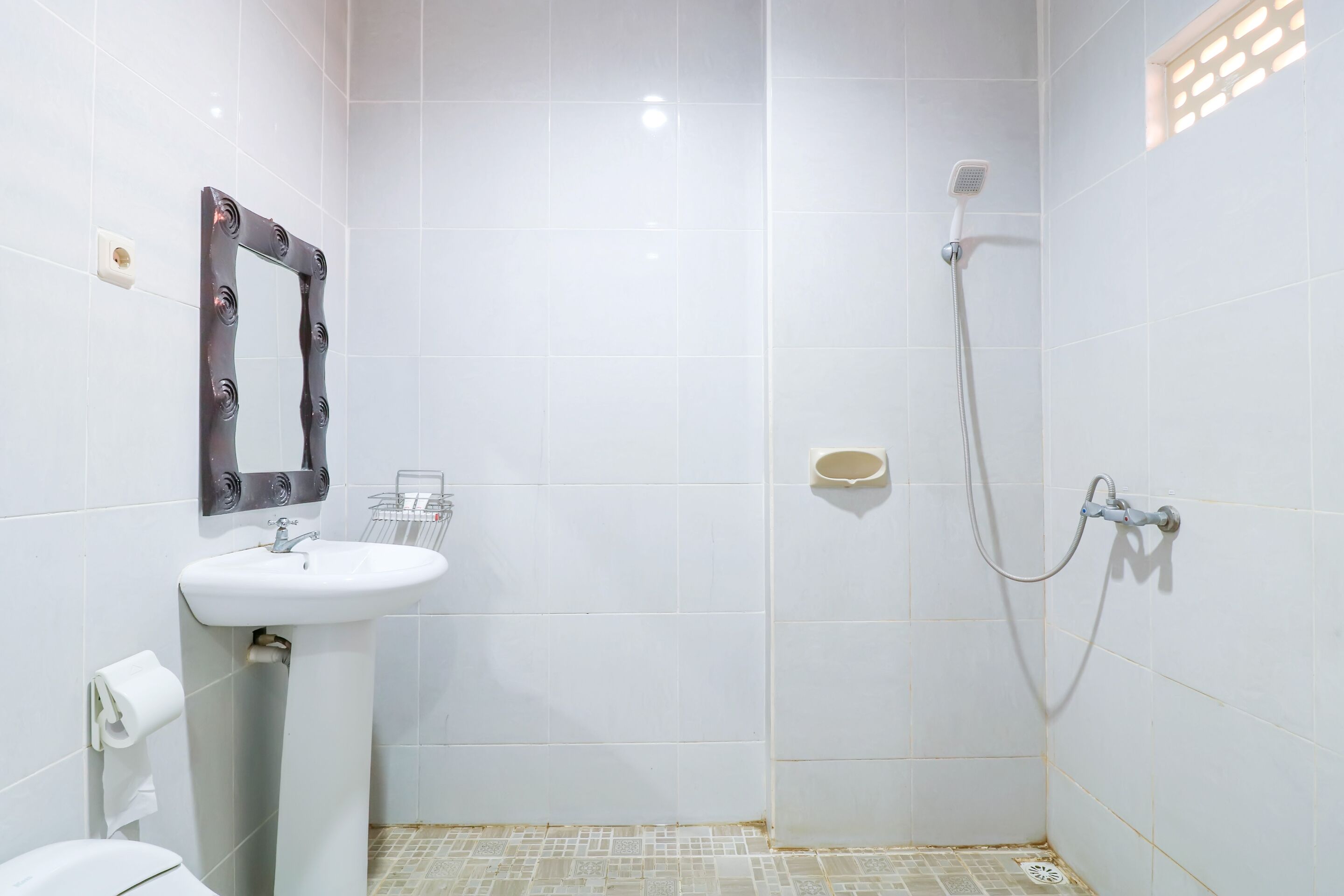 A bathroom with a white sink, mirror, and shower.