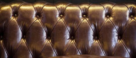 A tufted leather headboard with a dark background.