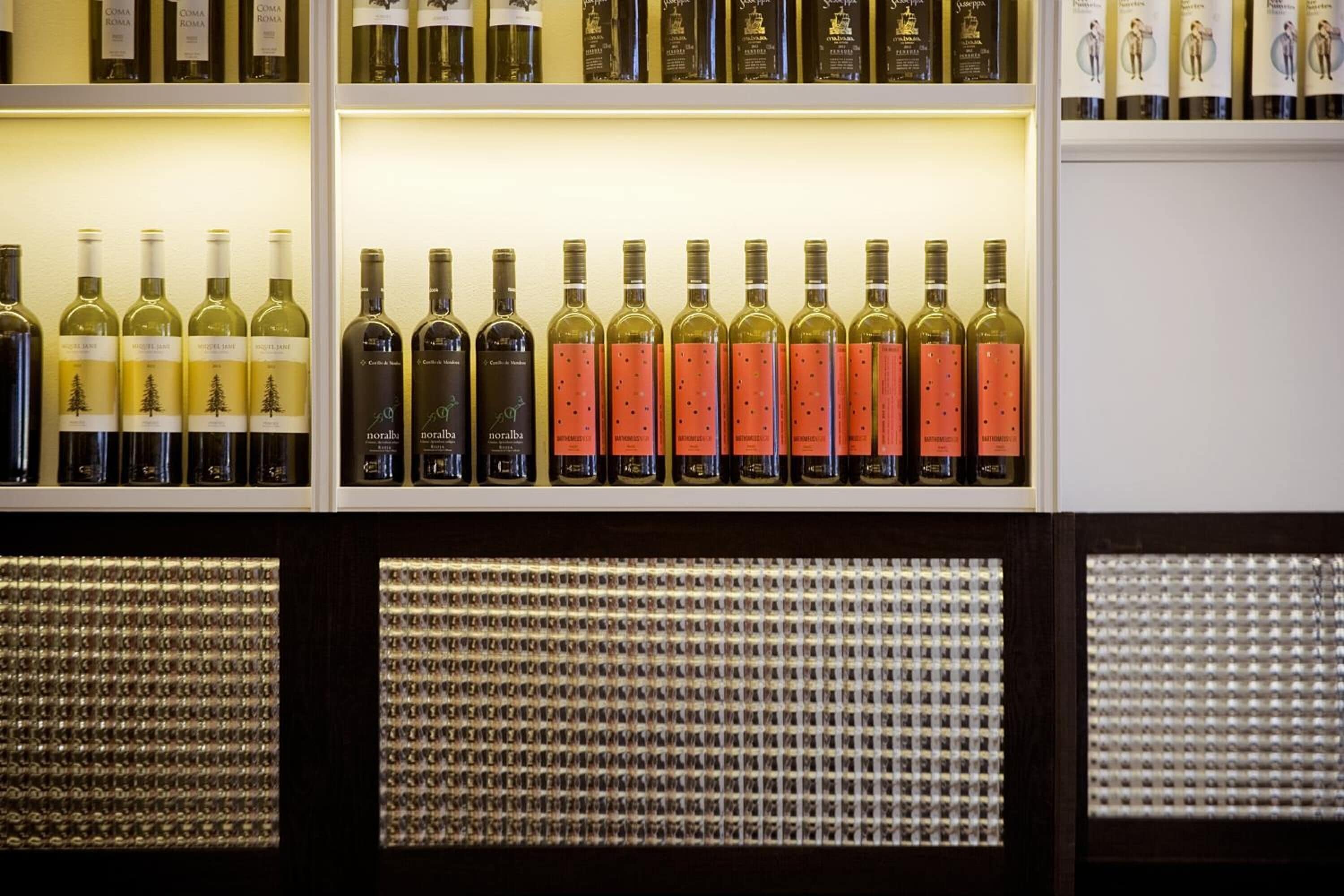Una exhibición de vinos con varias botellas organizadas por tipo y marca.
