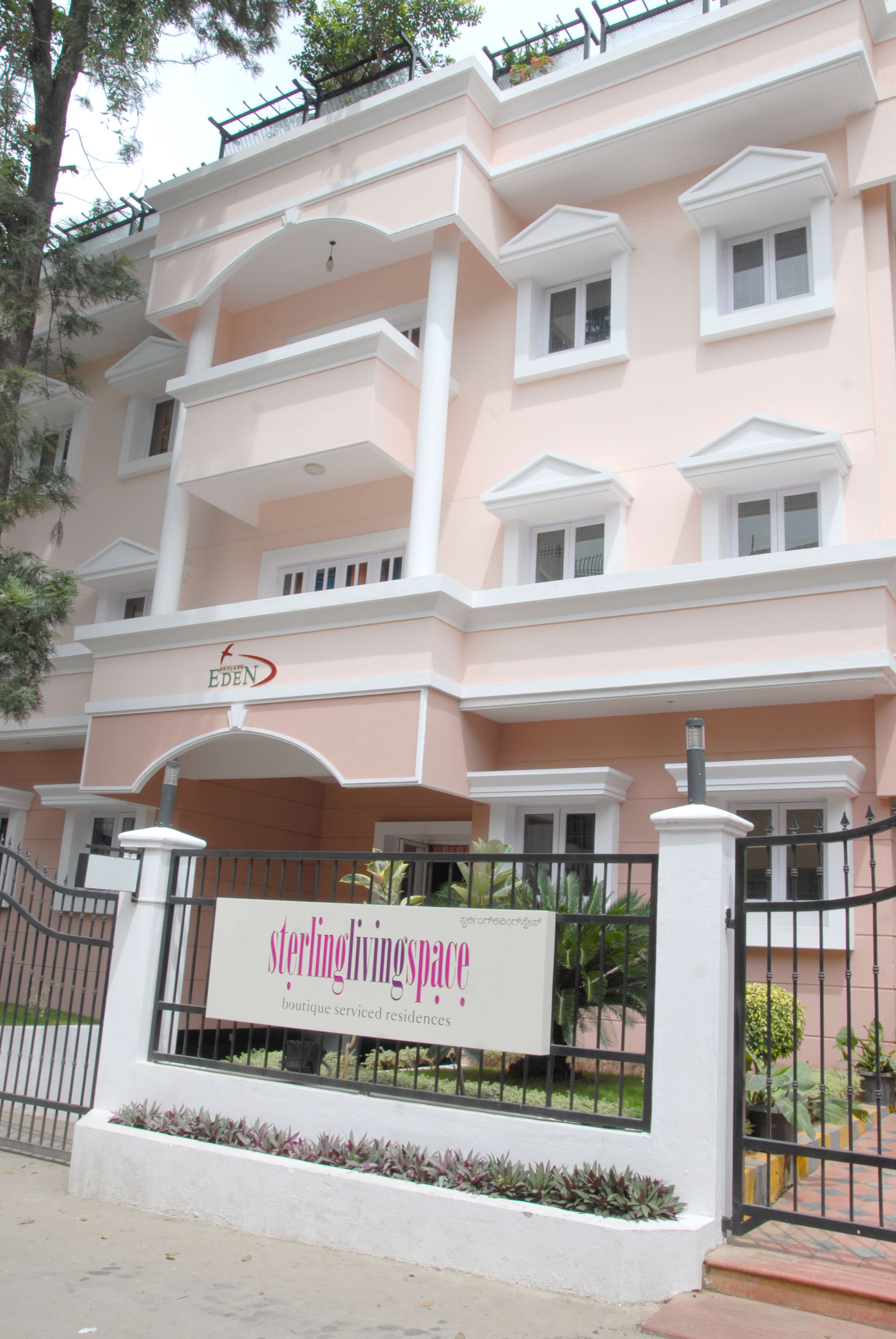 A multi-story building with a sign reading "Sterling Living Space" and "boutique serviced residences."