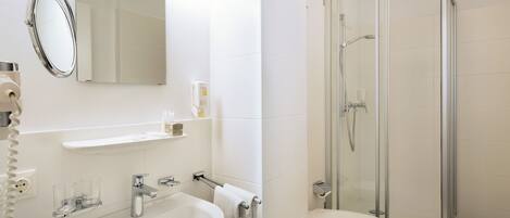 A modern bathroom with a sink, mirror, and shower.