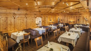 Un restaurante con interior de madera, varias mesas y sillas.