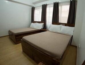 Ein Zimmer mit zwei Betten, Holz-Kopfteilen und Holzboden.